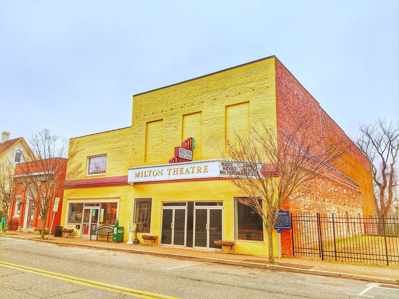 Front view of the vibrant yellow Milton Theatre, a historic venue in Milton, Delaware, known for live performances, comedy shows, and films.