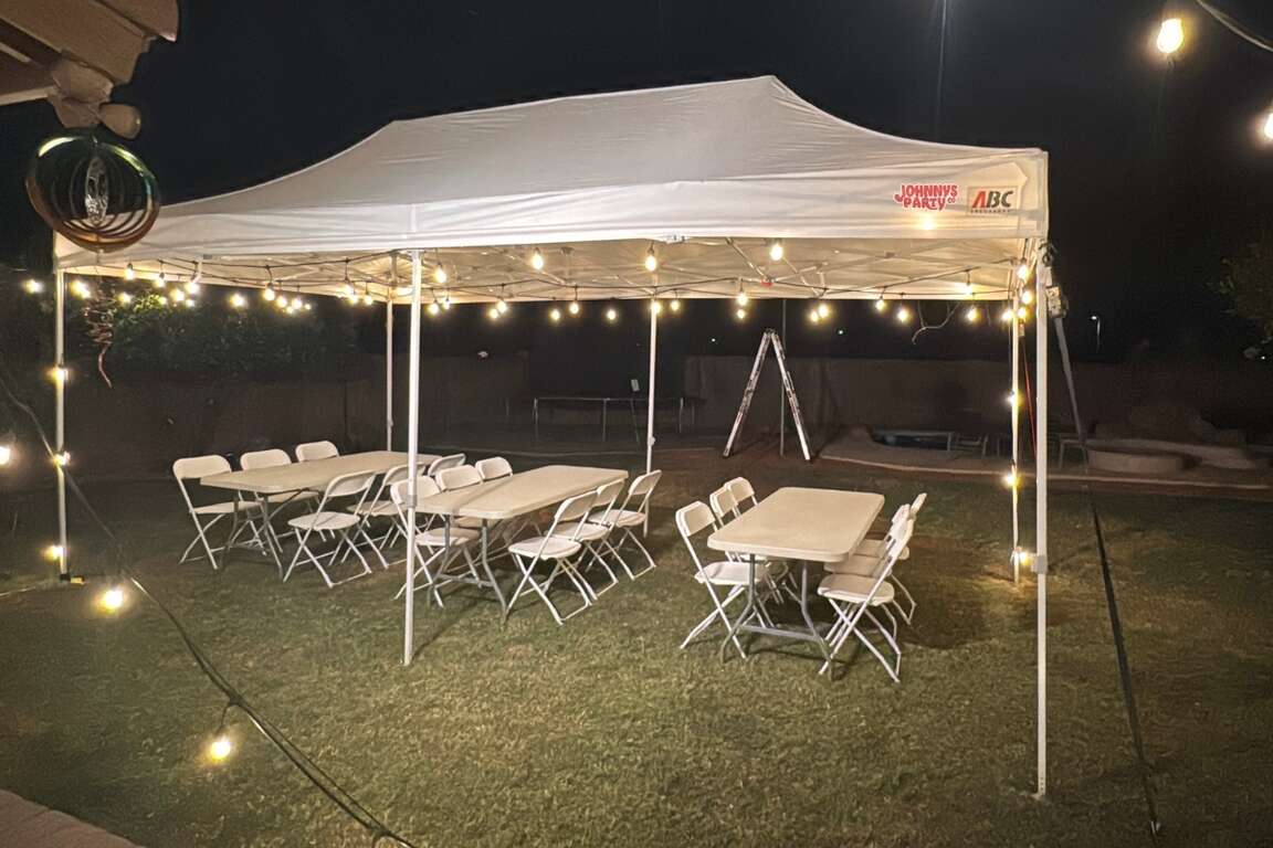 White folding chairs under a 10x20 canopy tent in Peoria, AZ