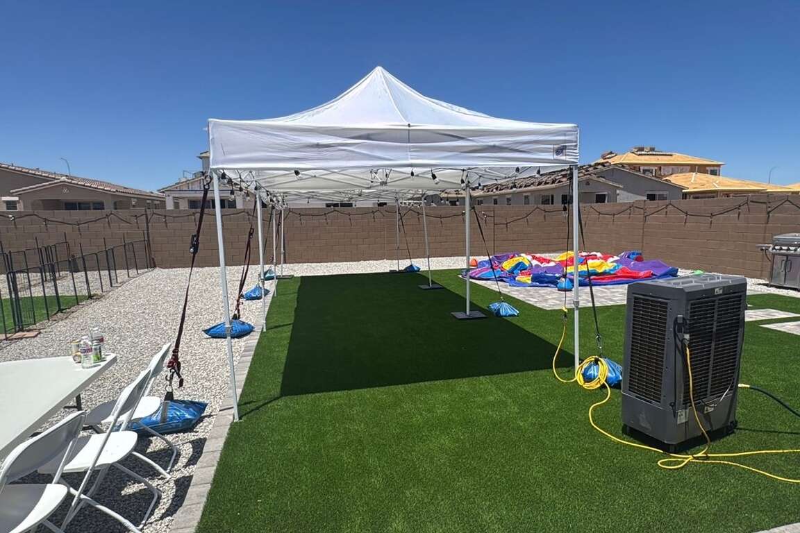 10x30 canopy tent rental paired with tables, chairs and a swamp cooler for an outdoor event