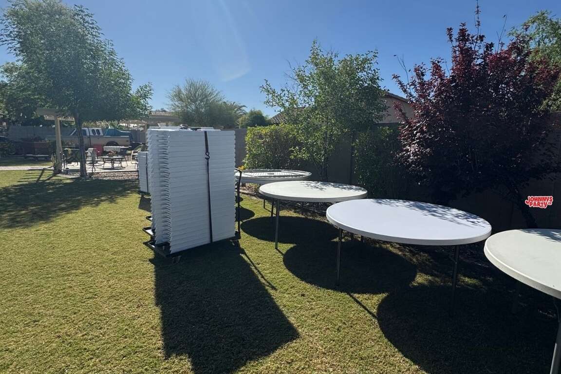 White resin chairs stacked on a chair dolly for delivery