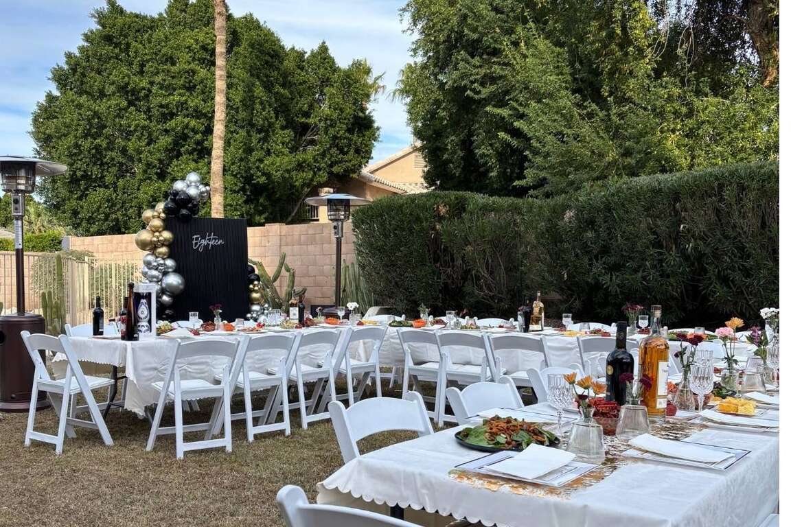 Party rental package with tables and white resin chairs set up for a backyard celebration