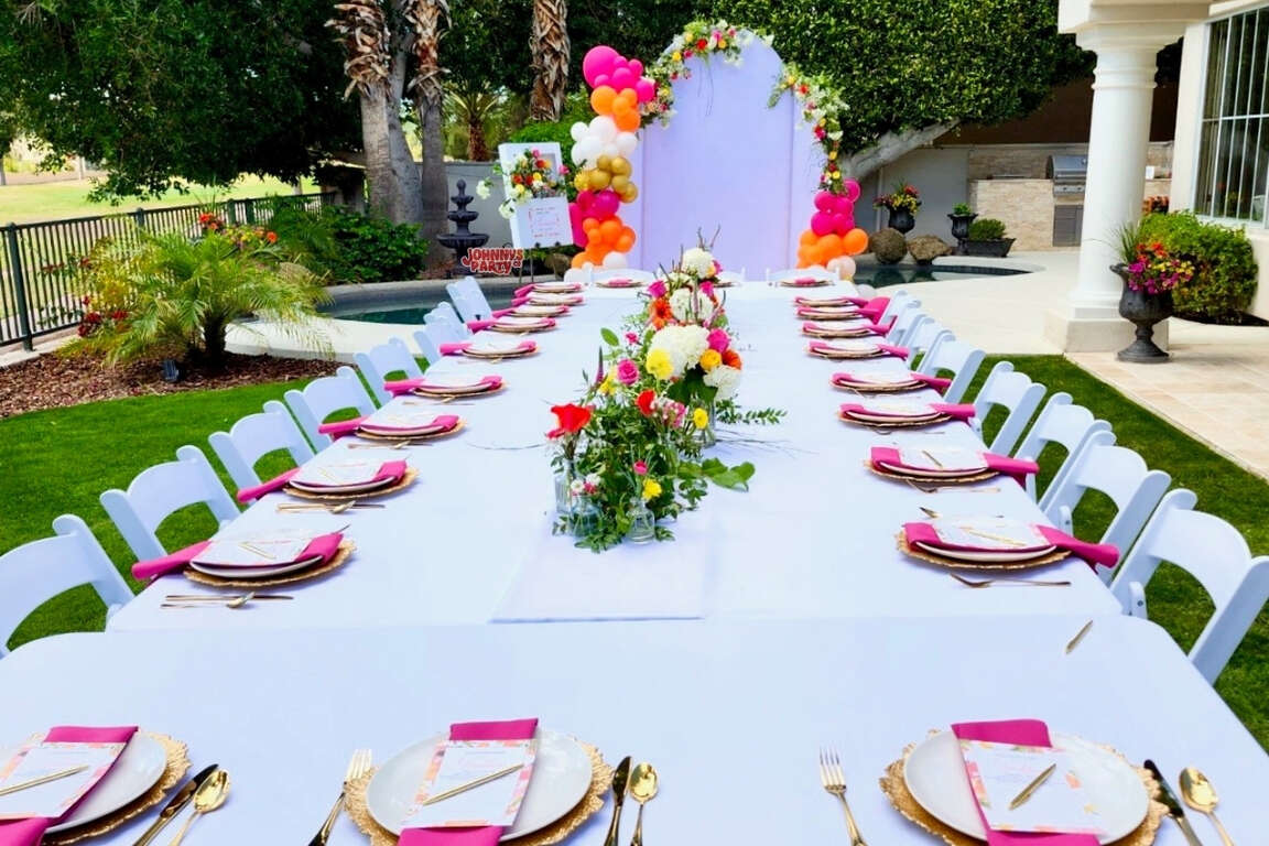 White resin chairs at table seating with arch backdrop, Avondale AZ