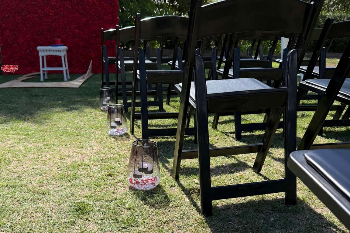 Black resin chairs lining an outdoor wedding aisle in Glendale, AZ