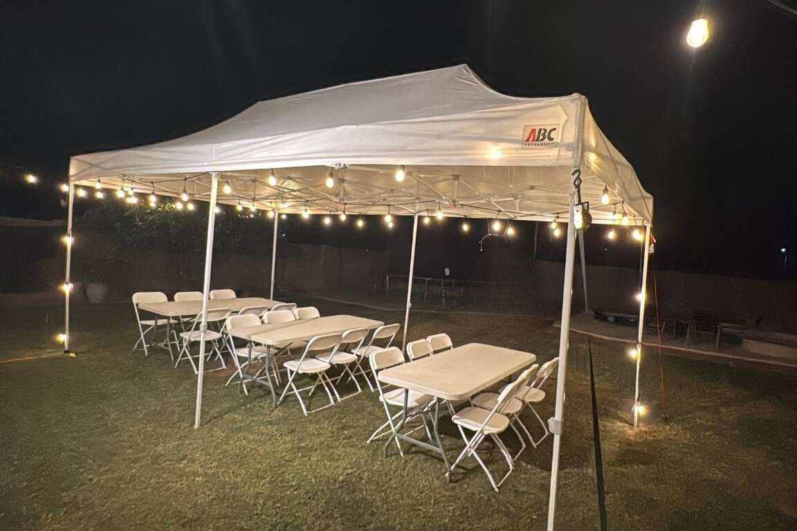 Canopy tent with table and chair rental set up in a Peoria backyard