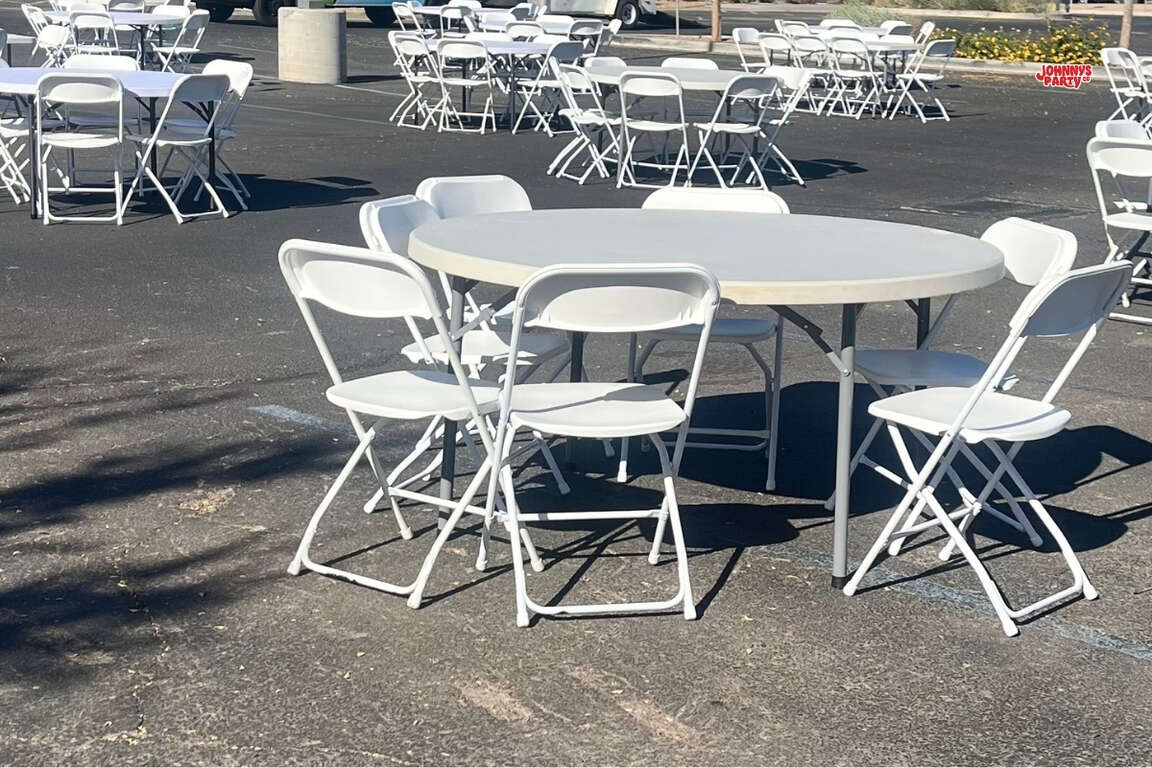 Round table and white chair setup at a corporate event