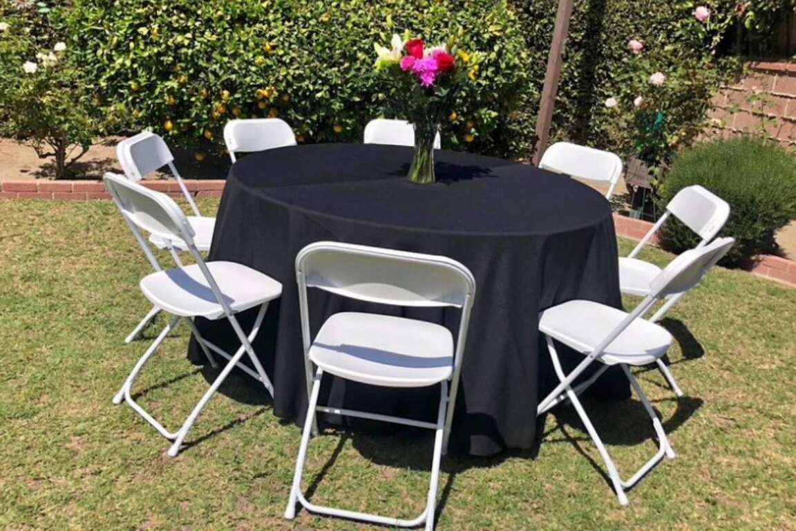 White round tablecloth linen with white resin chairs