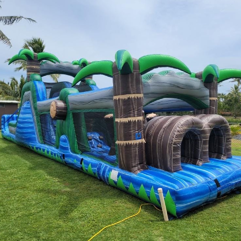 Expansive palm tree-themed inflatable obstacle course with multiple archways and slides, set up on a grassy area, perfect for adventure-filled party rentals in Oahu, HI, offered by Oahu Jump.