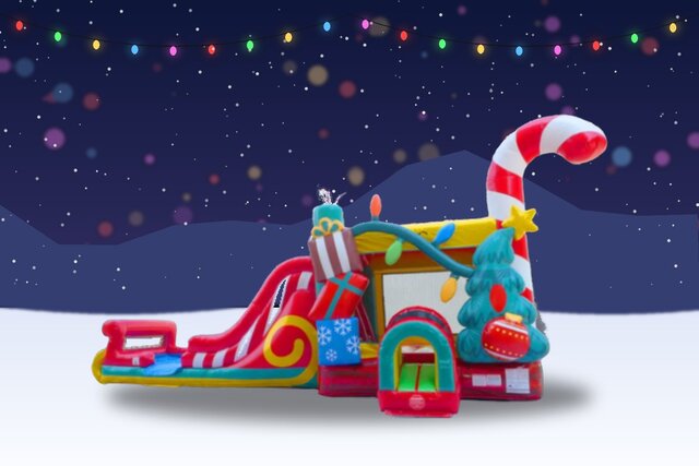 Christmas Wonderland mega combo inflatable with a sleigh-style slide and giant candy cane on a snowy evening