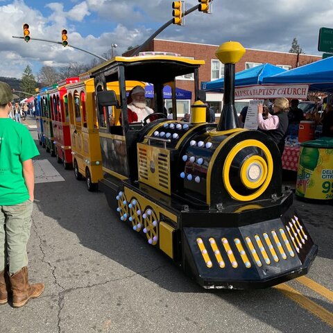 Jumpers trackless train rolling down a closed street at a holiday festival