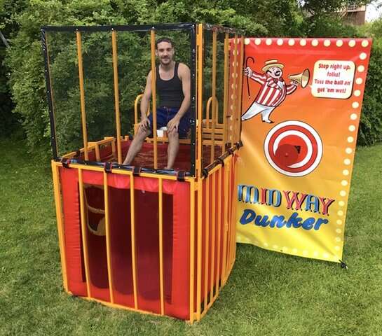 Tuskany Events Midway Dunker with a person sitting on the dunk seat.