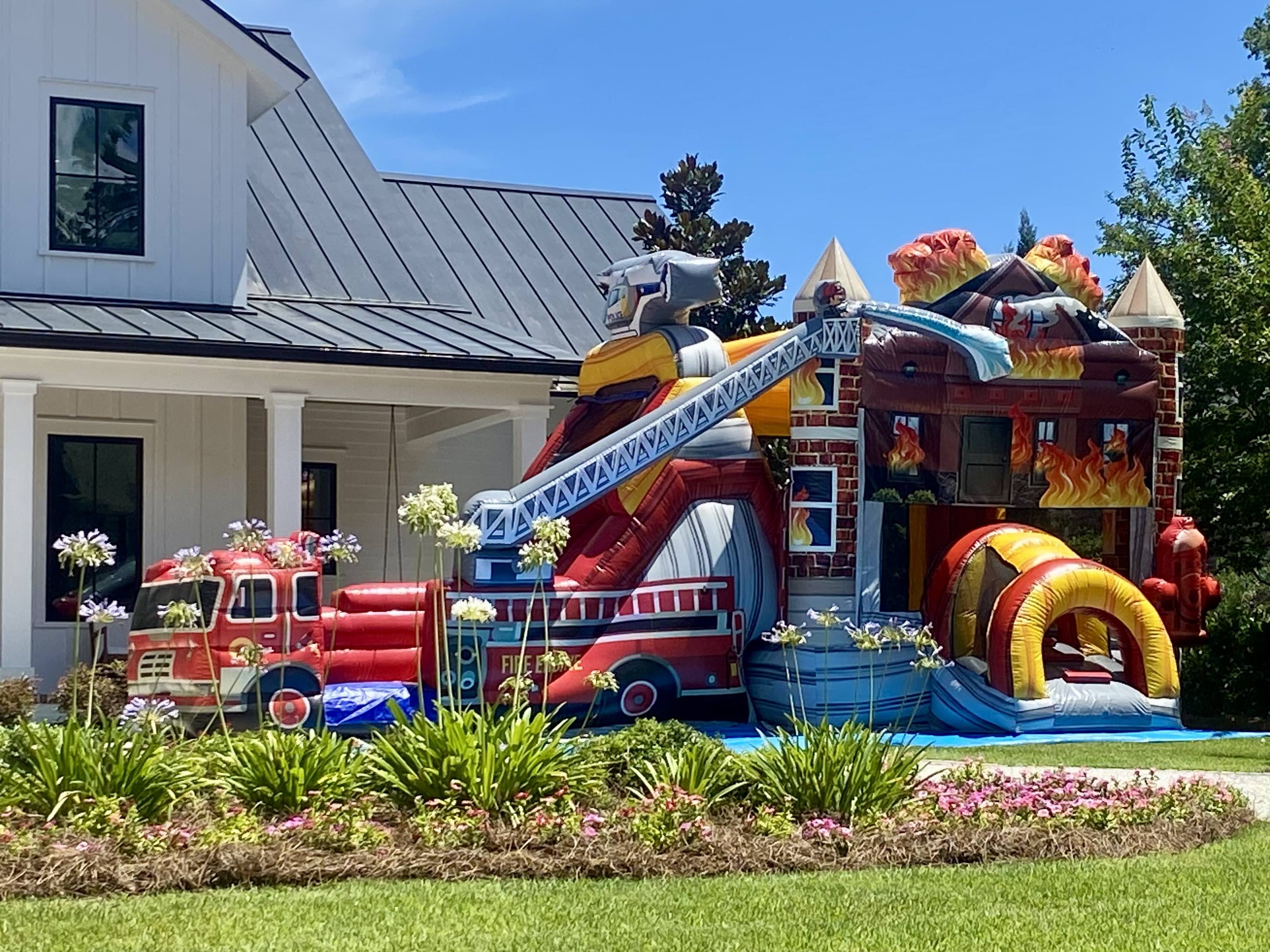 Mega Fire Truck bounce house with water slide combo rental set up in front of a house in Savannah GA