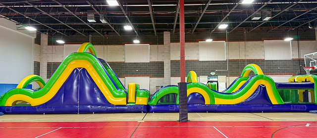 Large 65 foot inflatable obstacle course setup outdoors for Utah school and community events