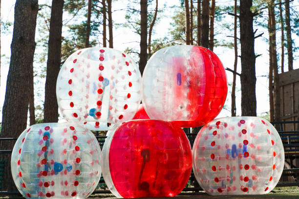 Bumper balls inflated and stacked on each other in front of trees