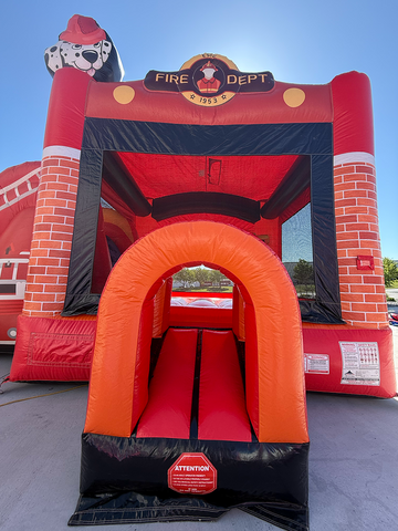 Fire Truck inflatable bounce house rental with slide set up on a clear day in a backyard