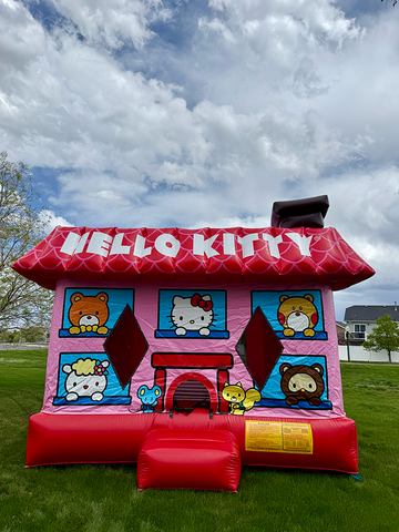 Pink and red Hello Kitty bounce house on grass under a cloudy sky for a birthday party.