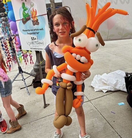 Child holding character anxiety from inside out 2 made as a balloon at a party.