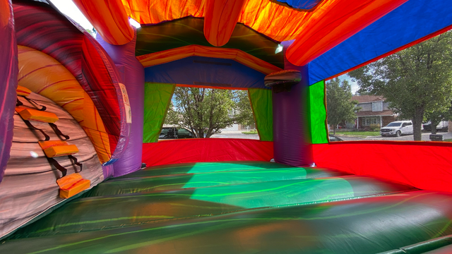 Inside Maui themed inflatable bounce house leading to a slide