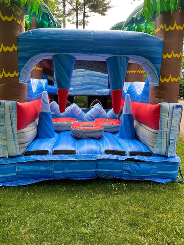 A shark themed bounce house rental in Salt Lake City with green palm trees and a shark tooth design on the top.