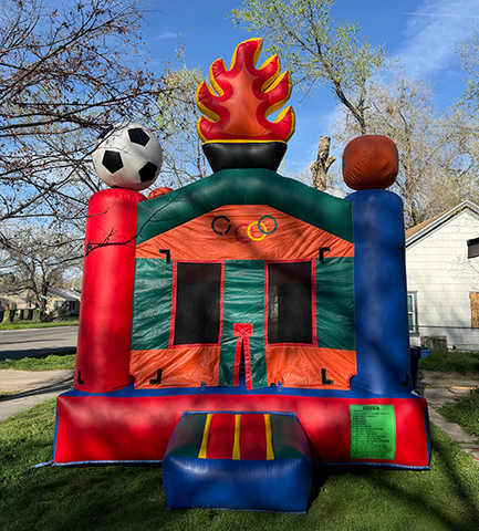 Olympic bounce house with sports balls on top set up in a backyard at a Childs birthday party
