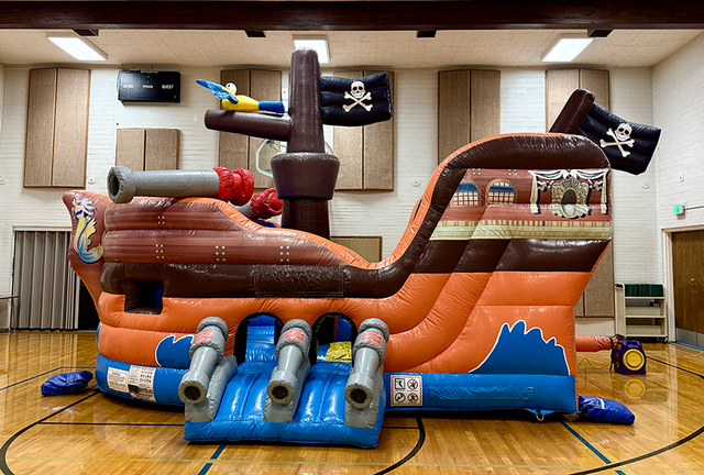 Pirate Ship bounce house rental set up in a school gym for a field day