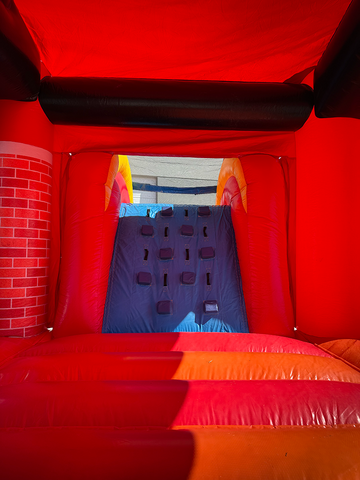 Fire Truck inflatable bounce house rental with slide set up on a clear day in a backyard