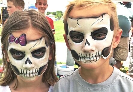 Skeleton face painting on two kids done by a professional artist.