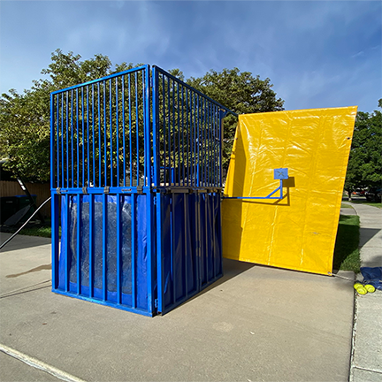 Blue and Yellow Dunk tank set up in a parking lot