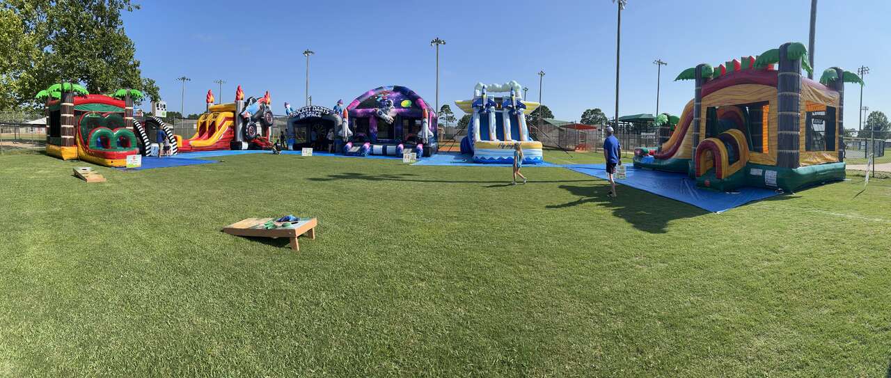 Jumptastic Navarre event setup — bounce houses, water slides, obstacle courses, and games at a community event