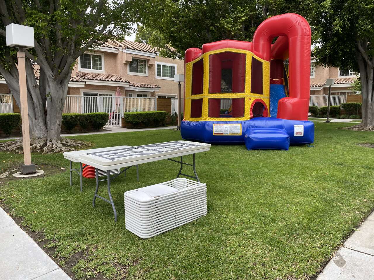 Backyard party setup with bounce house, tables, and chairs at a Downey home
