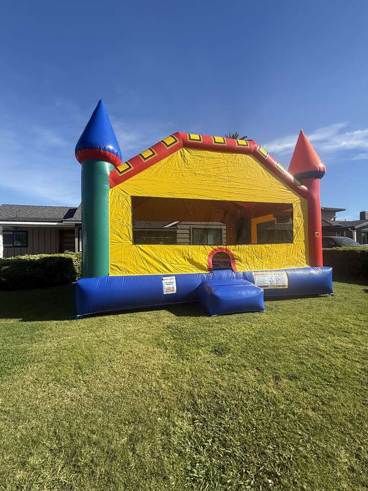 extra large castle bounce house with two basketball hoops set up at a home in Downey CA