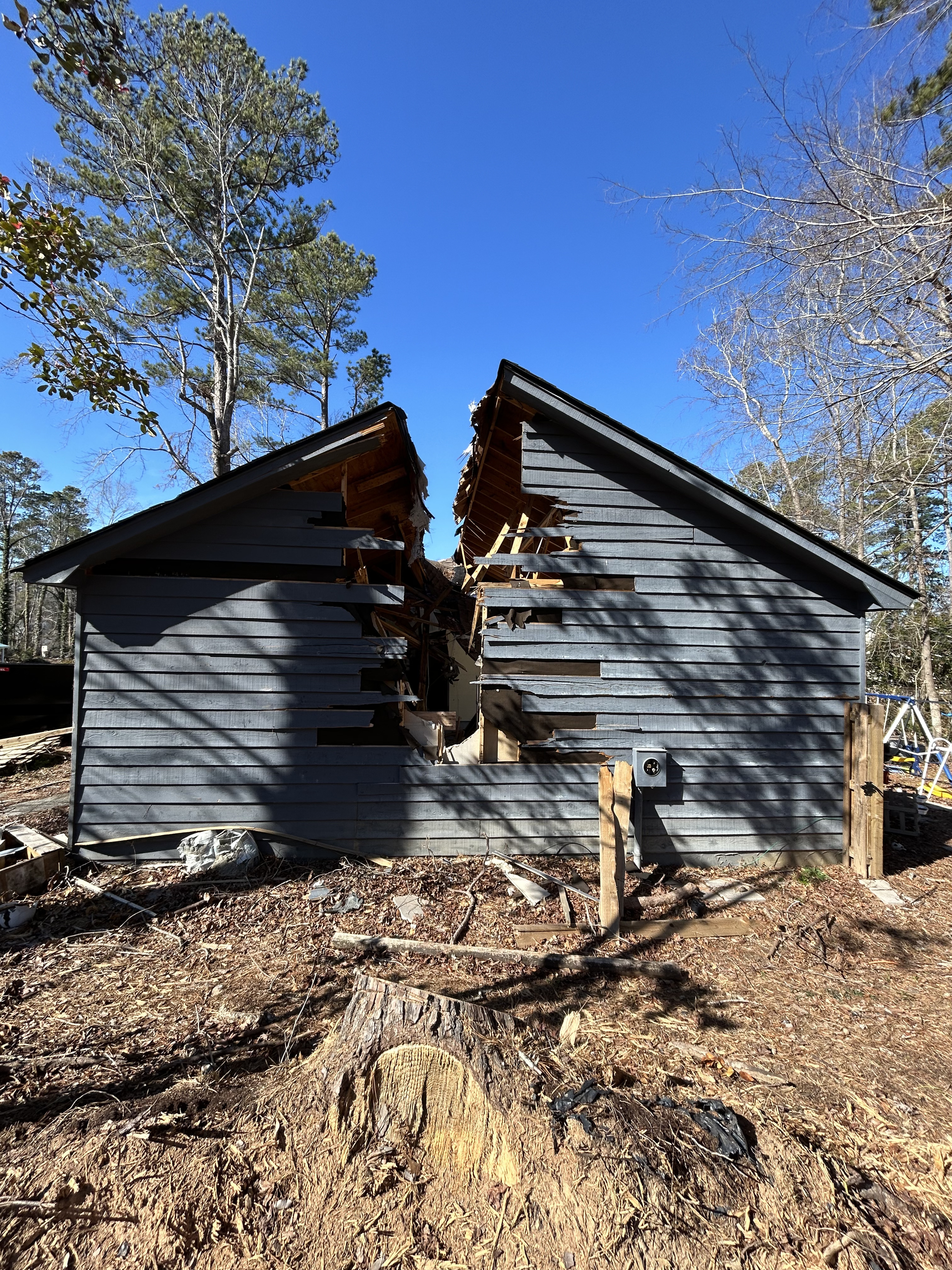 Junk Empire demolition site showing a house split in half during teardown.