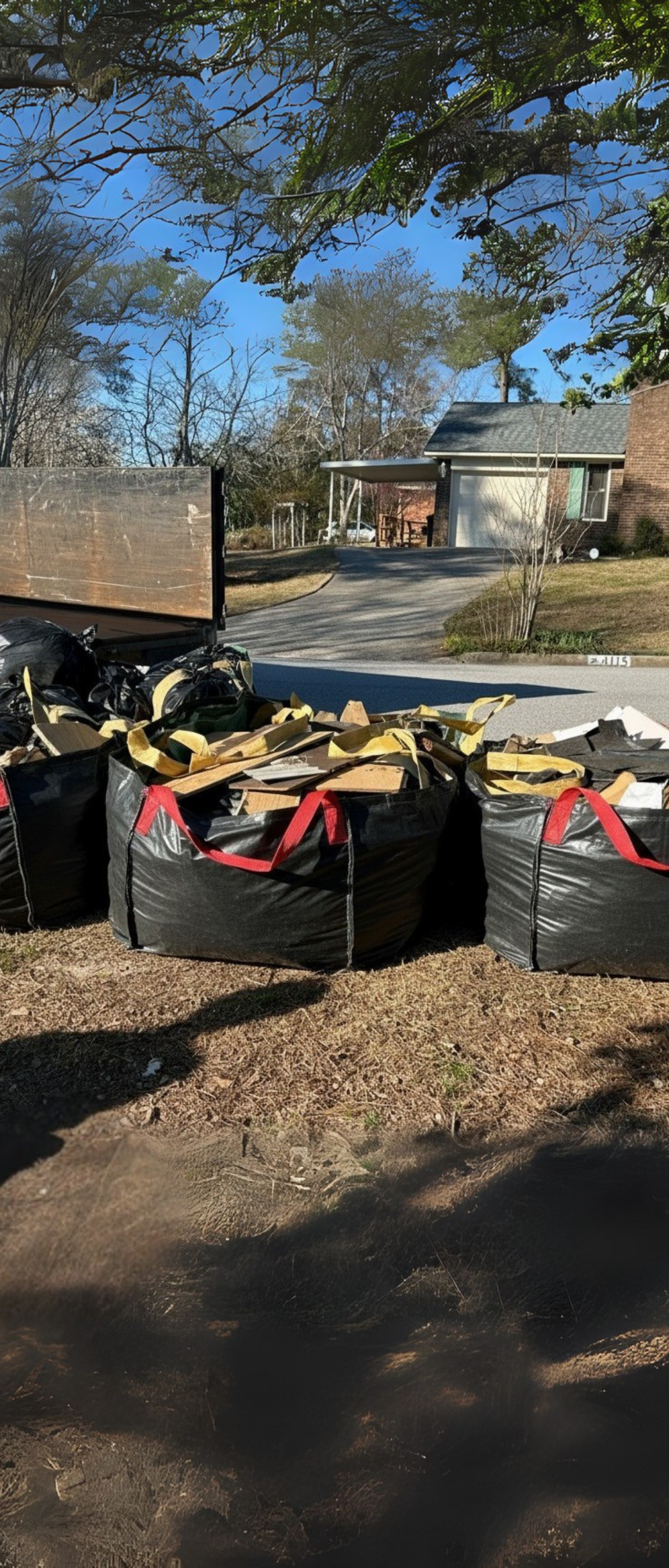 Junk Empire hauling service with large green debris bags filled with construction waste ready for pickup.