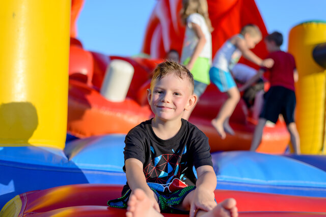 kid on bounce house in a large event