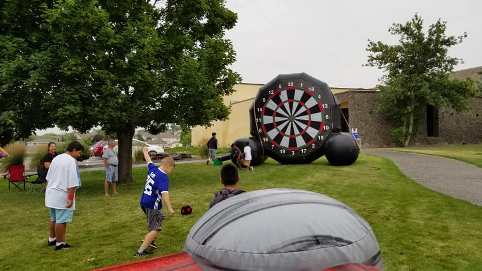 kids kicking soccer ball at giant dartboard