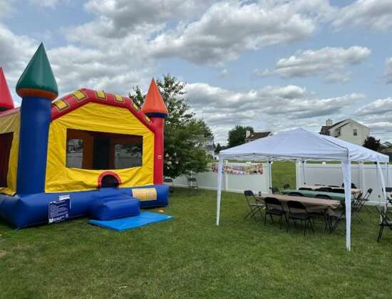 Backyard party setup with bounce house and tent rental from Keystone Bounce