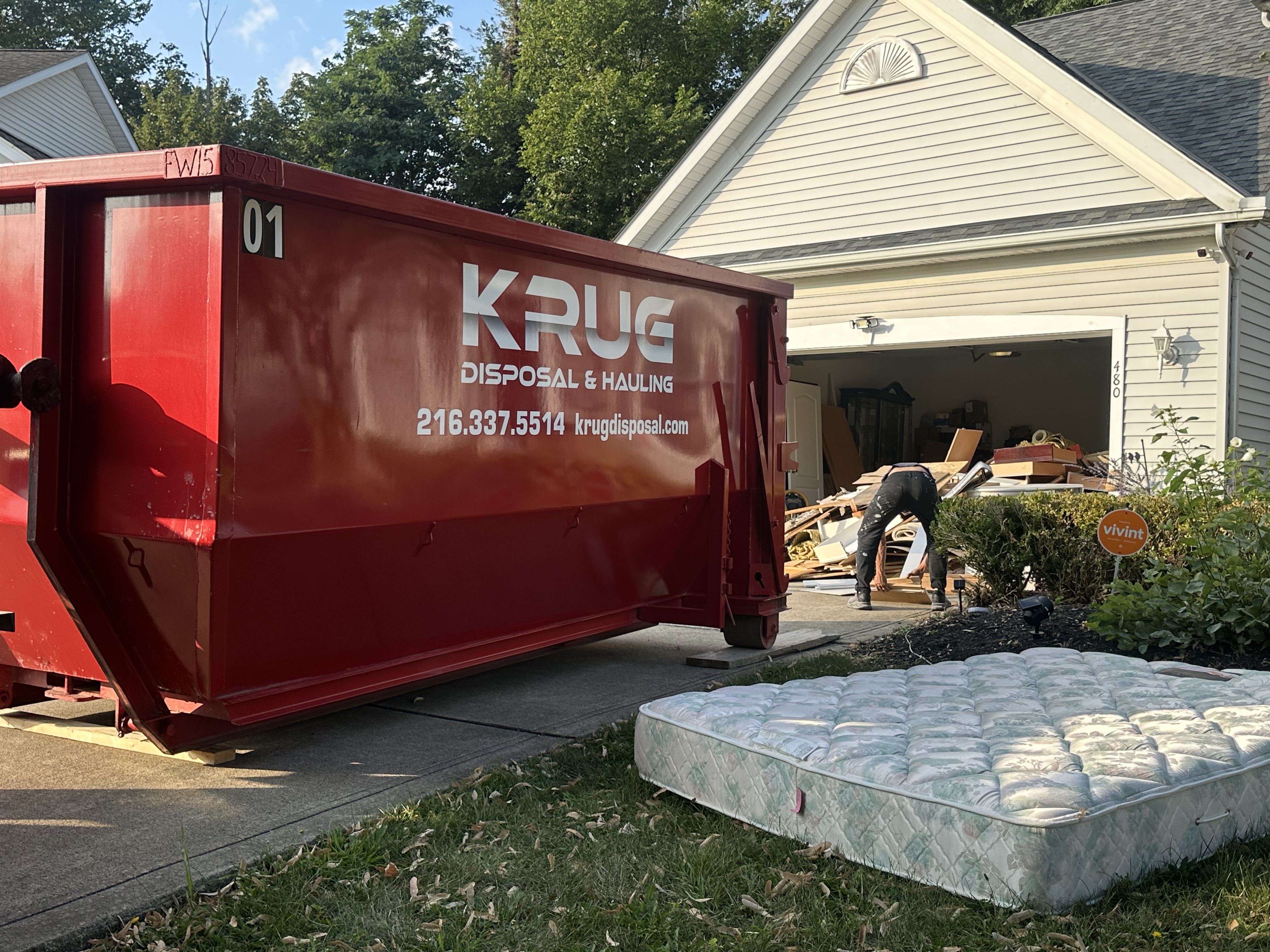 Krug Disposal red dumpster in driveway for home cleanout.