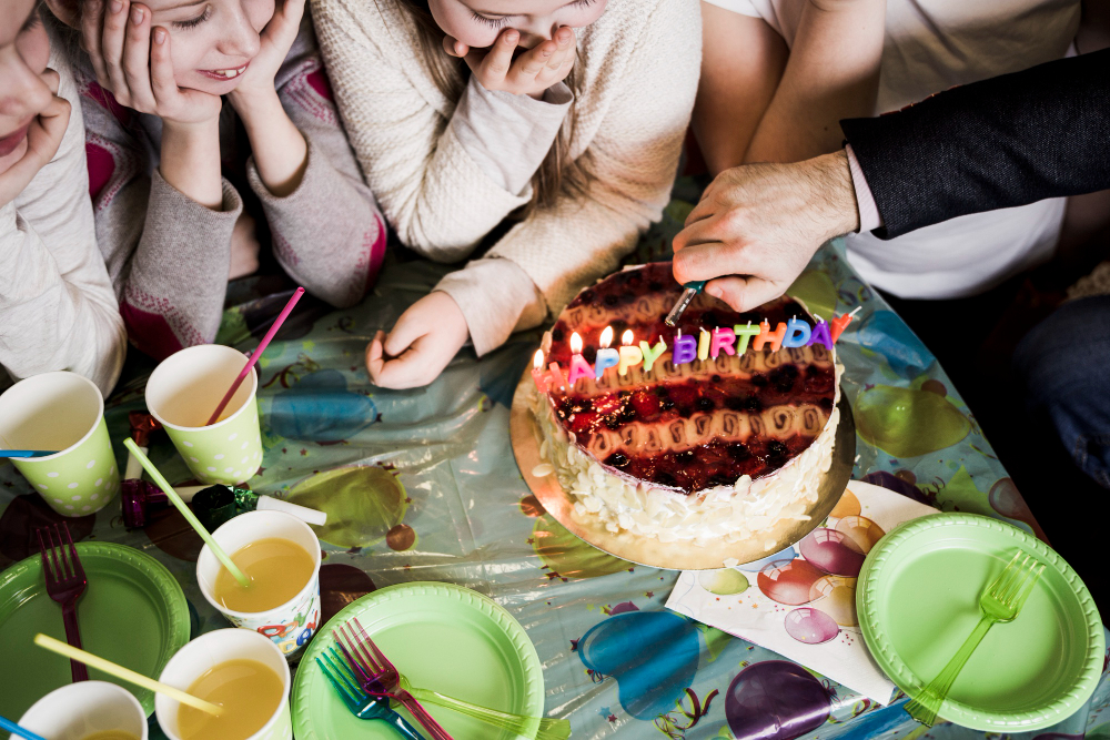 Children gathered around a birthday cake at a birthday party Children gathered around a birthday cake at a birthday party