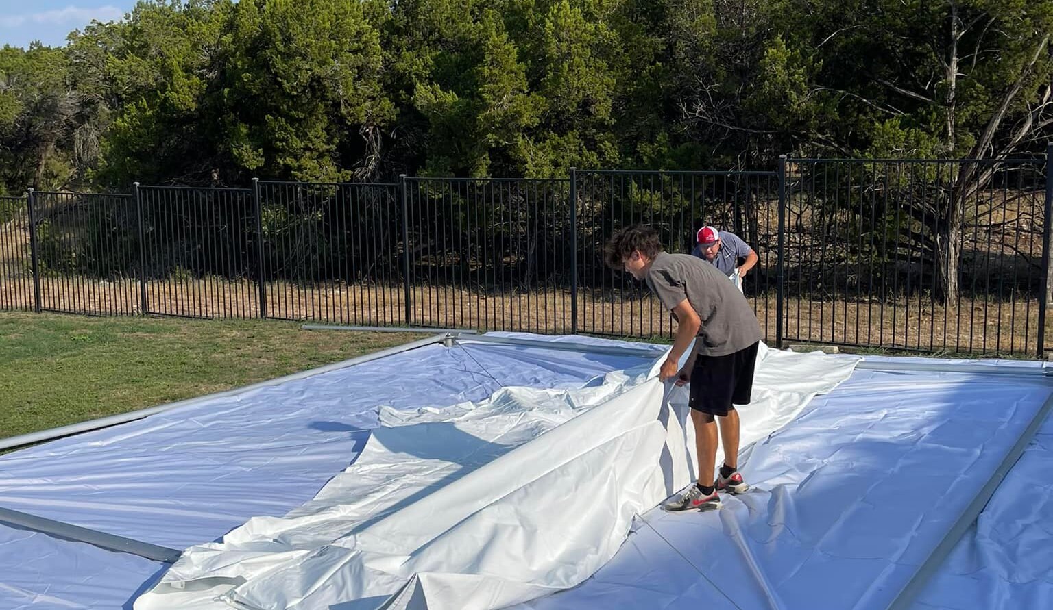 Trusted Exclusive Event Rentals workers professionally setting up a party tent outdoors Trusted Exclusive Event Rentals workers professionally setting up a party tent outdoors