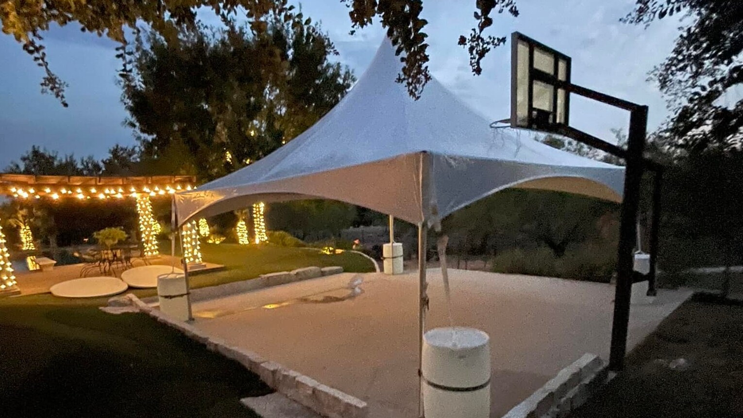 Outdoor event tent decorated with string lights, set up by Exclusive Event Rentals Outdoor event tent decorated with string lights, set up by Exclusive Event Rentals