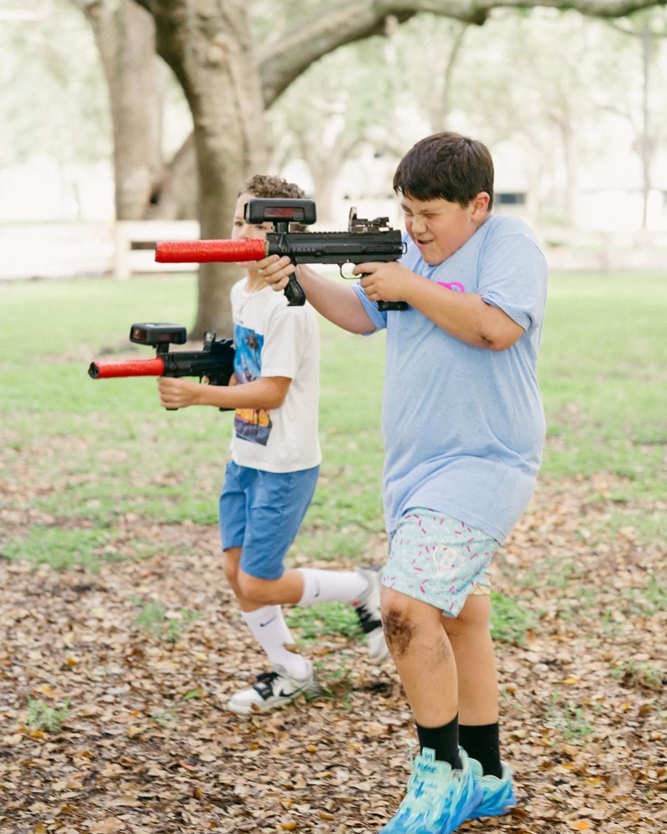 Kids running with laser tag phasers at a Miami party
