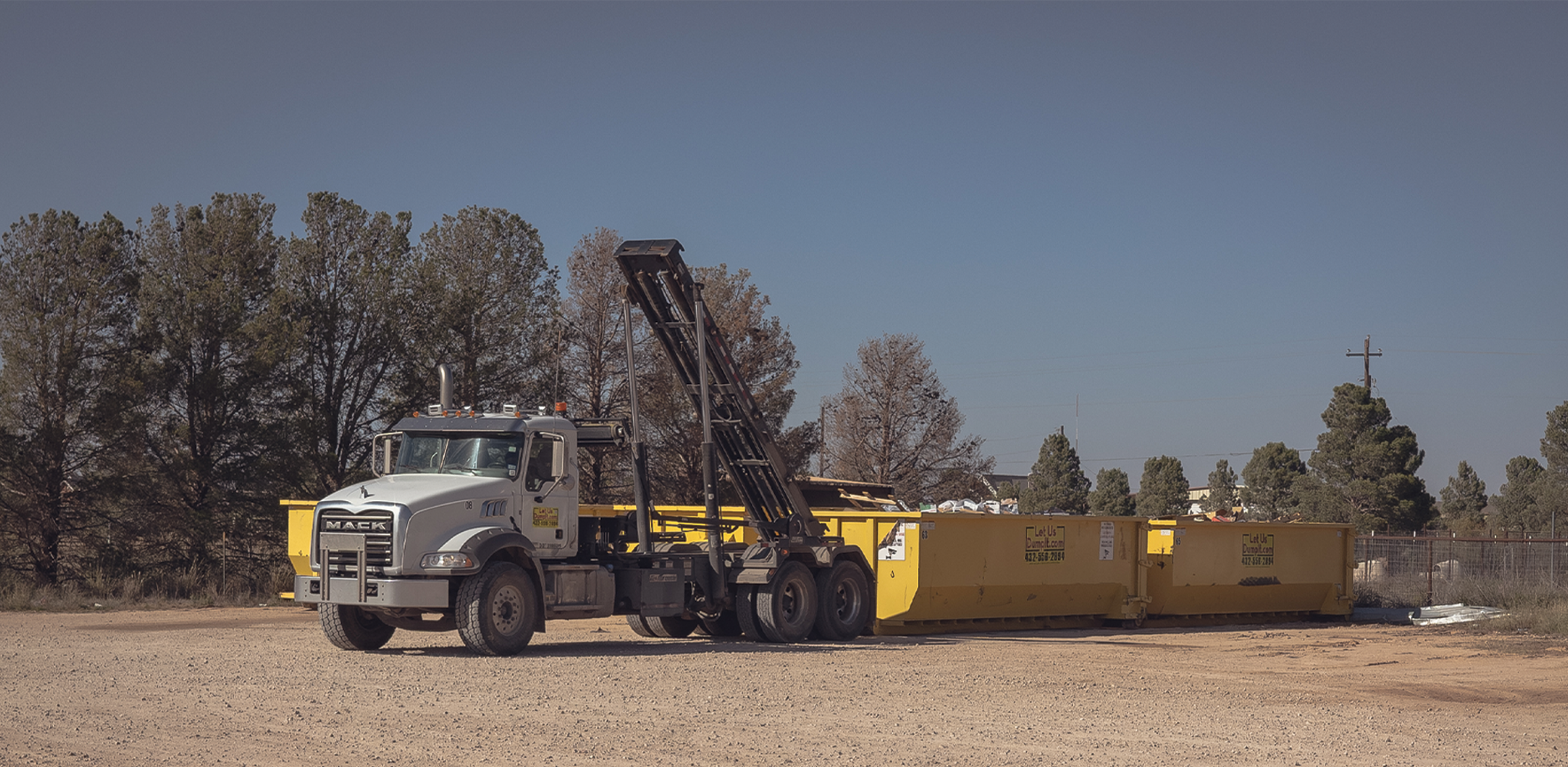 Let Us Dump It roll-off dumpster truck delivering in Midland, TX