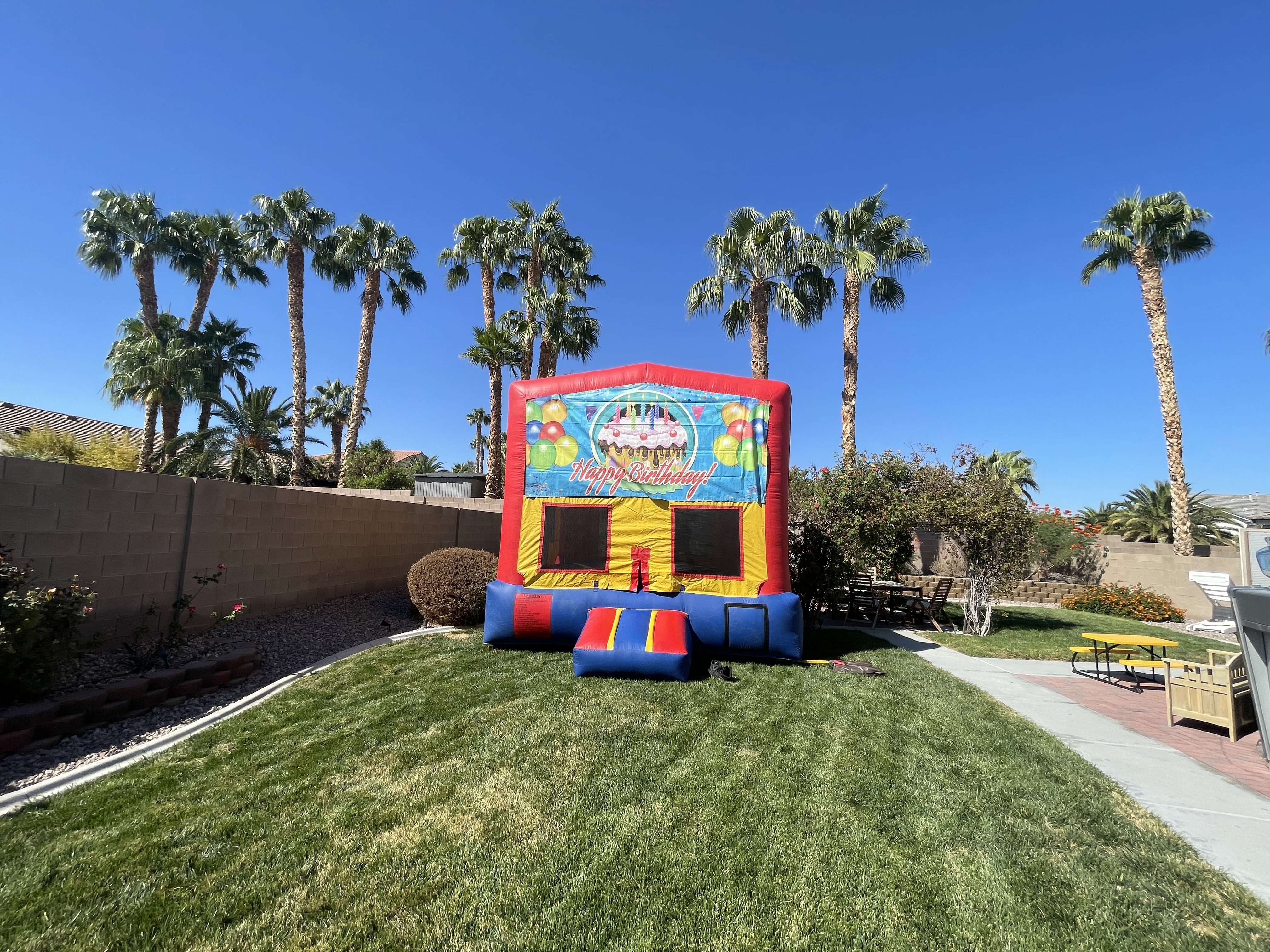 Happy Birthday bounce house with colorful balloons and cake design, available for rental from Liberty Party Jumpers for birthday parties in Las Vegas and Henderson