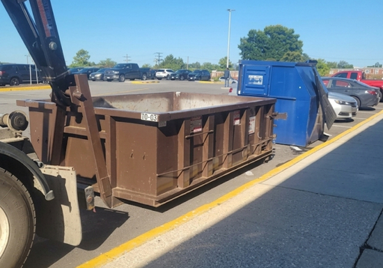 MAC Dumpsters truck delivering a commercial roll-off dumpster