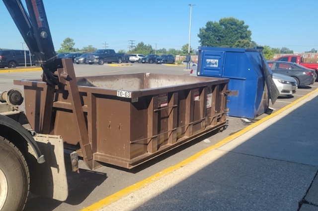 MAC Dumpsters truck delivering a commercial roll-off dumpster