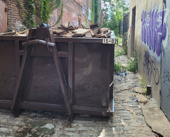 Construction dumpster loaded with demolition debris by MAC Dumpsters
