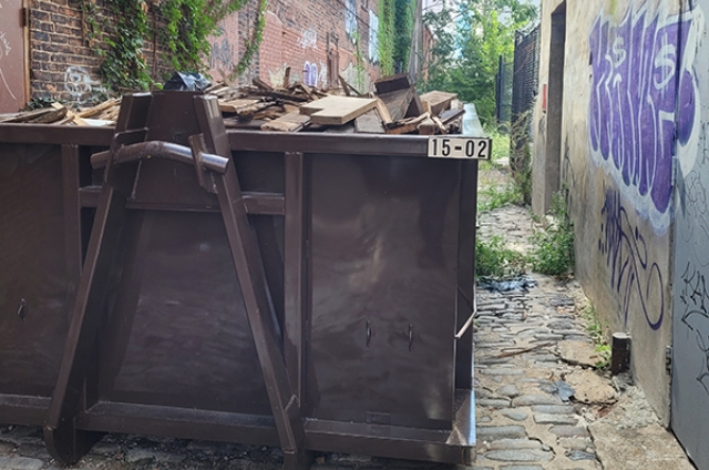 Construction dumpster loaded with demolition debris by MAC Dumpsters