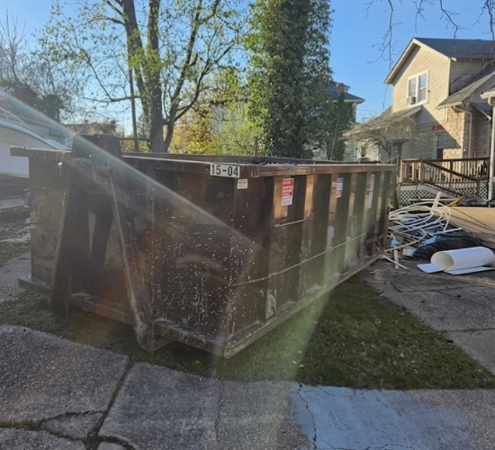 Roll-off dumpster from MAC Dumpsters on a residential lawn