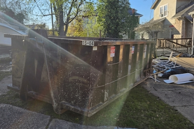 Roll-off dumpster from MAC Dumpsters on a residential lawn