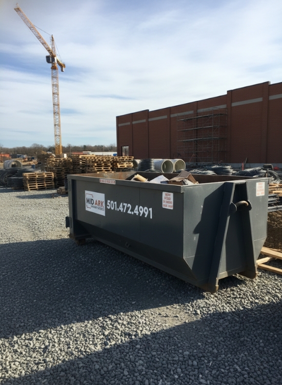 Roll-off dumpster at a construction site, provided by Mid-Ark Dumpsters LLC