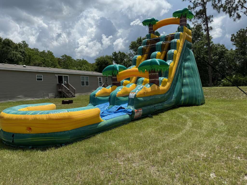 Tall tropical dual-lane water slide professionally set up on grass